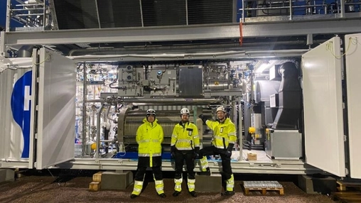 Technicians standing inside a containerised energy system