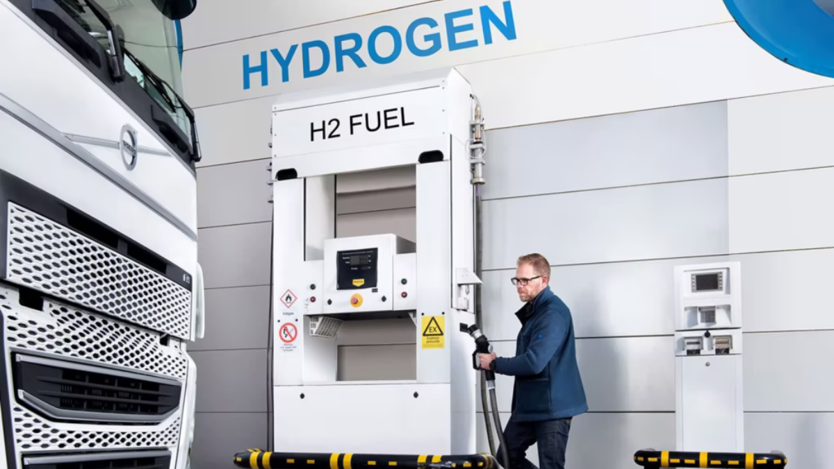 Man refuelling hydrogen truck at H2 fuel station in industrial setting