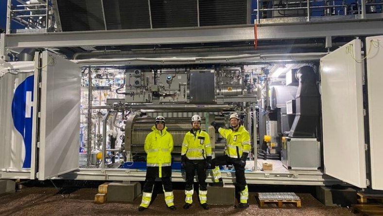 Technicians standing inside a containerised energy system
